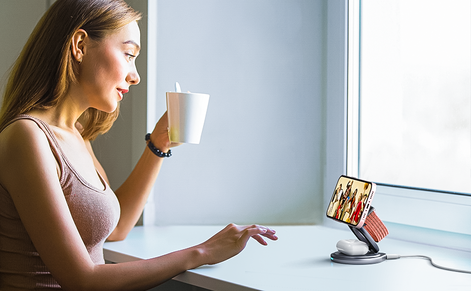 a women using 3-in-1 swivel wireless charger to charger her phone and watch videos while enjoying coffee