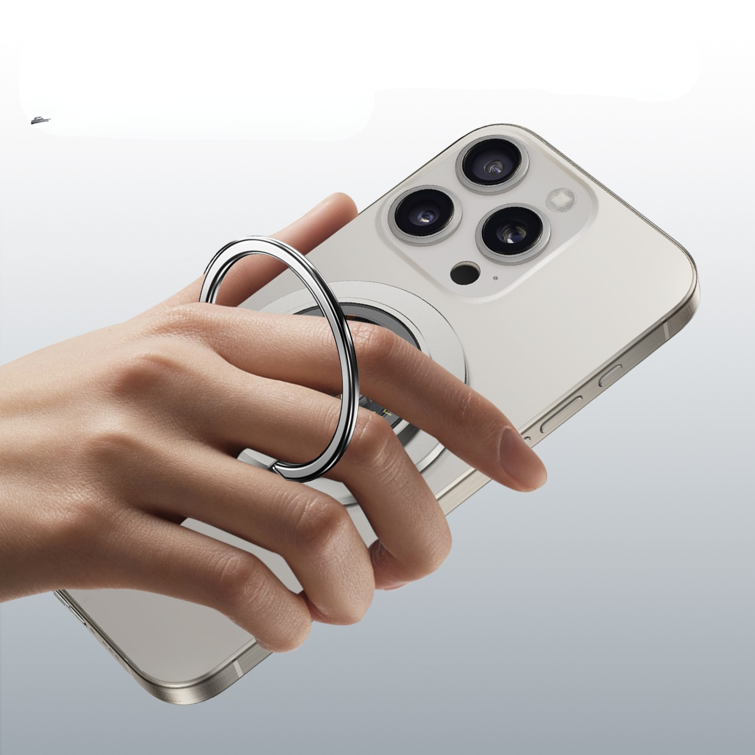 Hand holding a smartphone with a flexring magnetic 3-in-1 charger with steel holder on a light gray background