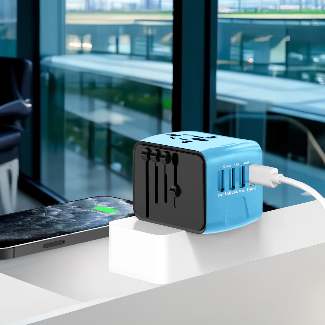 Blue and black International travel adapter with multiple ports on a table with a smartphone in the background.